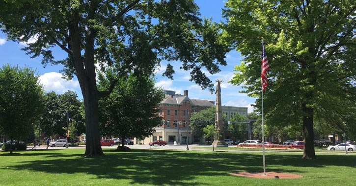 american flag, trees, and monument in downtown glens falls