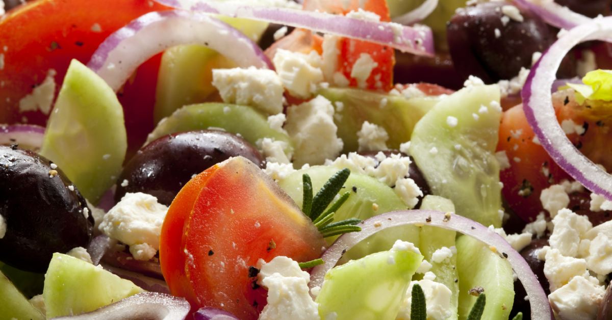 tomatoes, red onions, cucumbers, and feta cheese in a salad