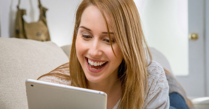 a woman looking at a tablet and smiling