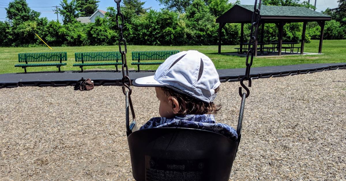 toddler on swing, view from the back