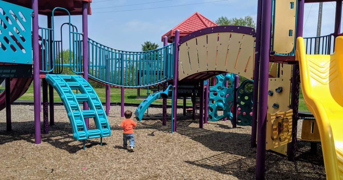 toddler running towards a playground