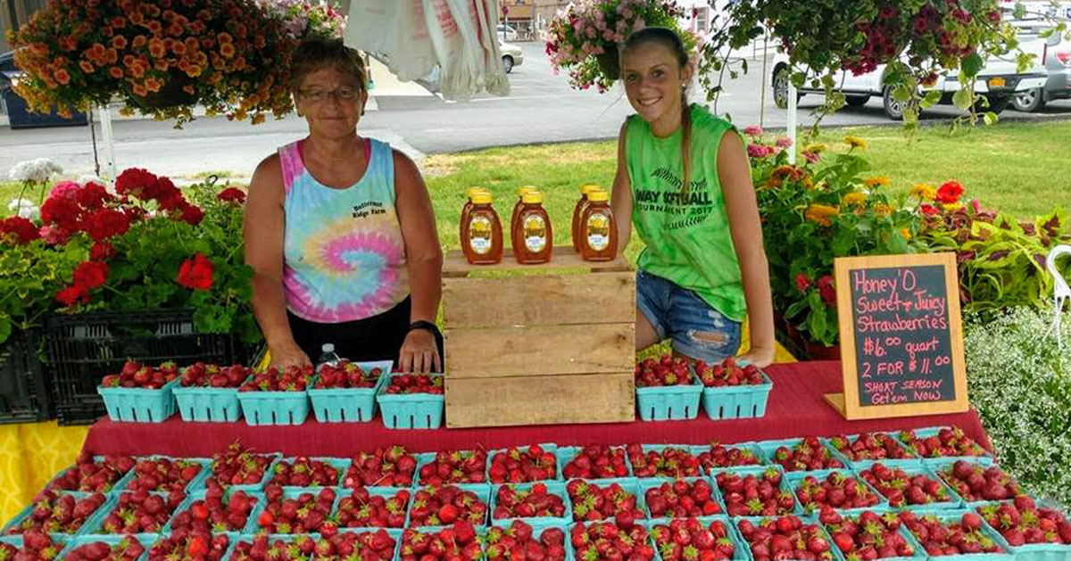 two women at farm stand with strawberries